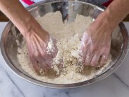 Vue rapprochée des mains mélangeant beurre et farine — Photo de stock