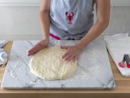 Cropped view of person forming dough on marble slab — Stock Photo