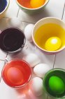 Крупный план окраски пасхальных яиц в мисках — стоковое фото
