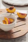 Миска зі свіжих шматочків персика — стокове фото