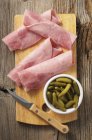 Rolled slices of ham and gherkins — Stock Photo