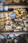 Vue rapprochée des petits pains à la cannelle avec des étiquettes sur le stand du marché — Photo de stock