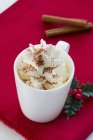 Closeup view of whipped cream with cinnamon in cup — Stock Photo