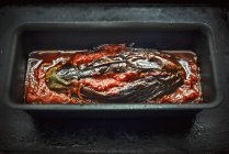 Імам Bayildi - фаршировані, тушкована баклажани в чорний блюдо над столом — стокове фото
