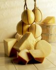 Bolas enteras de queso y cuñas cortadas - foto de stock