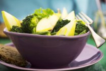 Broccoli and pear salad in purple bowl — Stock Photo