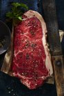 Steak de bœuf cru avec sel et poivre — Photo de stock