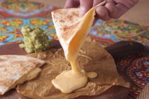 Quesadilla with guacamole over paper — Stock Photo