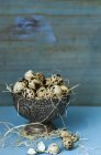 Quail eggs with straw in metal bowl — Stock Photo