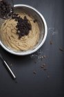 Primo piano vista di aggiungere pulsanti di cioccolato alla pasta in ciotola di miscelazione — Foto stock