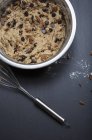 Closeup view of chocolate chip cookie dough with pecan nuts in mixing bowl — Stock Photo