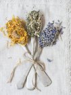 Getrockneter Lavendel, Mädesüß und Ringelblume auf Silberlöffeln — Stockfoto