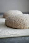 Vue rapprochée de deux boules de pâte saupoudrées de farine — Photo de stock