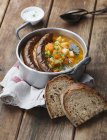 Vista elevata della zuppa di zucca e patate con salsicce e pane — Foto stock