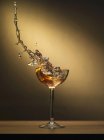 Cocktail splashing out of glass — Stock Photo