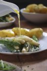 Pouring Melted butter over asparagus — Stock Photo