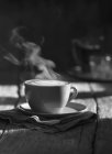 Cup of steaming cappuccino — Stock Photo