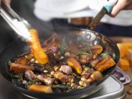 Citrouille frite avec bacon et ail dans la poêle — Photo de stock