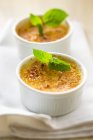 Close up view of Crema Catalana with leaves in bowls — стоковое фото