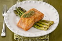 Fried salmon on green asparagus — Stock Photo