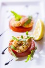 Prawns on tomato slices with arugula — Stock Photo