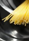 Espaguetis sin cocer en sartén - foto de stock
