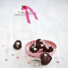 Ameixas em chocolate decorado com corações de açúcar — Fotografia de Stock