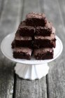 Stack of brownies on cake stand — Stock Photo