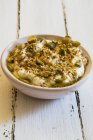 Hummus con dukkah - mezcla de nuez árabe y especias en un tazón - foto de stock