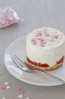 Cheesecake with redcurrants and sugar hearts — Stock Photo