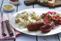 Chouriço com saladas de batata e tomate — Fotografia de Stock