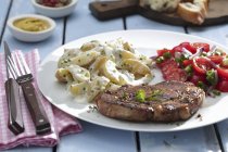 Carne di maiale con insalate di patate e pomodoro — Foto stock