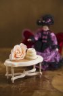 Closeup view of praline on small table with flower and doll — Stock Photo