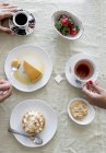 Zugeschnittene Ansicht menschlicher Hände und verschiedener Desserts, Tee und Kaffee — Stockfoto