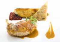 Stuffed guinea fowl with chorizo served with pepper chutney and fried aubergine on white background — Stock Photo
