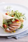 Un involucro con pollo affumicato e verdure su piatto bianco sopra asciugamano — Foto stock