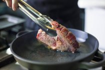 Koch bereitet Steak zu — Stockfoto