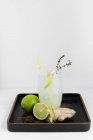 Vue rapprochée du gingembre et du soda citron vert avec des ingrédients sur un plateau verni — Photo de stock