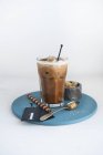 Glass of hazelnut iced coffee with brown sugar cubes and wafer roll — Stock Photo