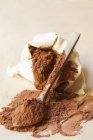 Vista de cerca del cacao en polvo en un saco y en una cuchara - foto de stock