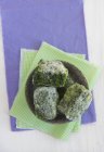 Porções de espinafre congeladas na placa sobre toalha verde — Fotografia de Stock
