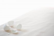Elevated view of white egg shells on a white tablecloth — Stock Photo