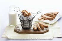 Elevated view of Cantucci in wire basket and on chopping board — Stock Photo