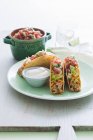 Hühnchen-Tacos mit Avocado-Salsa auf Teller über Holztisch — Stockfoto