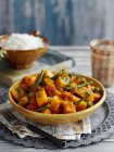 Creamy pumpkin and bean curry in yellow plate  over towel — Stock Photo