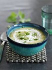 Parsnip and apple soup with curry in green bowl over table — Stock Photo