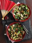 Mushroom and bok choy stir fry in red bowls  over towel with chopsticks — Stock Photo
