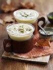 Closeup view of autumnal chicken soup in glasses and cups — Stock Photo