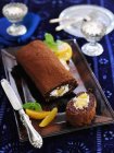 Closeup view of chocolate Swiss roll with peaches — Stock Photo