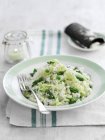 Risotto with green asparagus on plate with fork over towel — Stock Photo